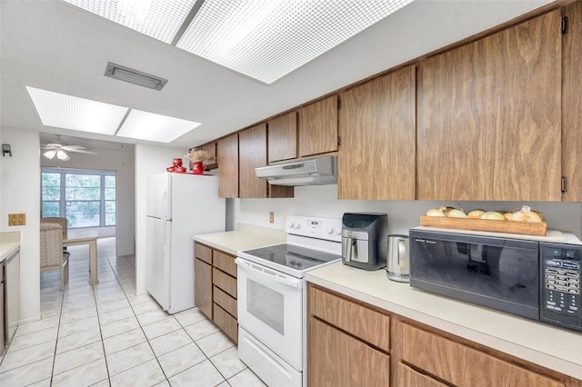 3840 Staysail Ln Unit 3840, Holiday, FL 34691 - kitchen featuring white appliances, under cabinet range hood, light tile patterned floors, and light countertops