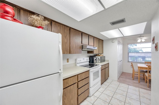 3840 Staysail Ln Unit 3840, Holiday, FL 34691 - kitchen featuring white appliances, under cabinet range hood, light countertops, light tile patterned flooring, and ceiling fan