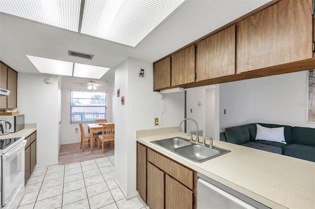 kitchen featuring white range with electric stovetop, a skylight, sink, light tile patterned flooring, and ceiling fan