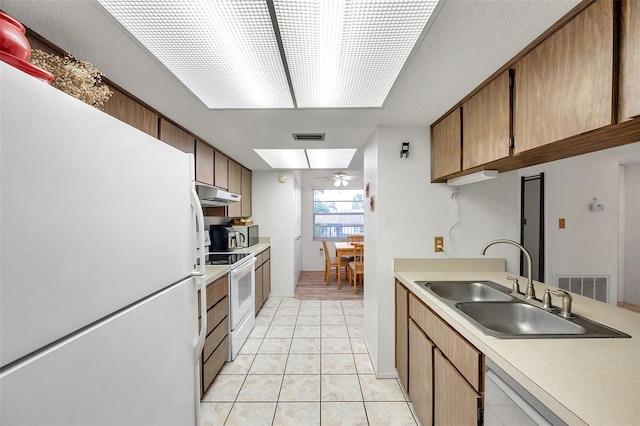 kitchen with ceiling fan, sink, white appliances, and light tile patterned floors