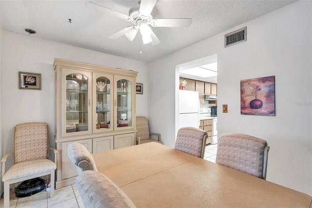 dining space with a textured ceiling, ceiling fan, and light tile patterned floors