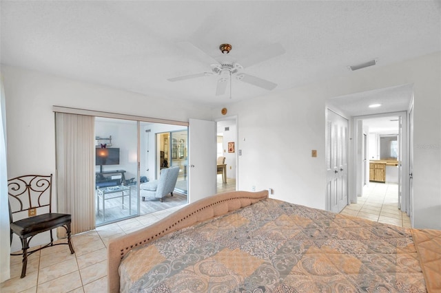 tiled bedroom with a textured ceiling and ceiling fan