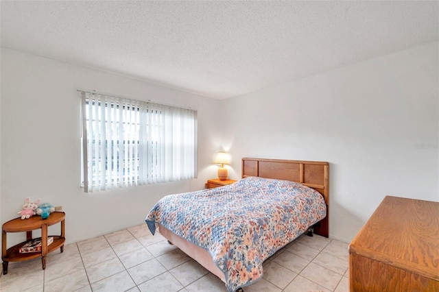 bedroom featuring a textured ceiling and light tile patterned flooring