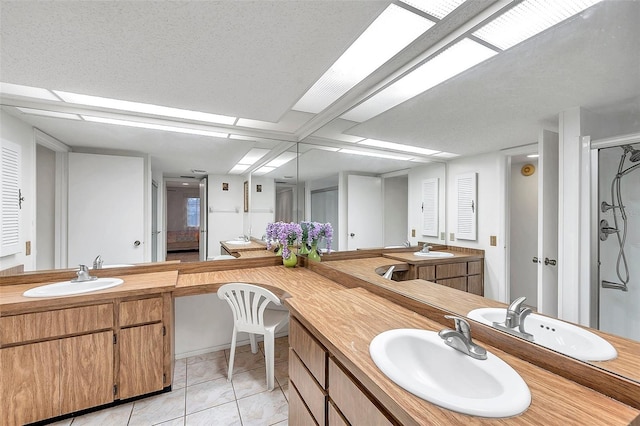 bathroom featuring a textured ceiling, walk in shower, tile patterned floors, and vanity