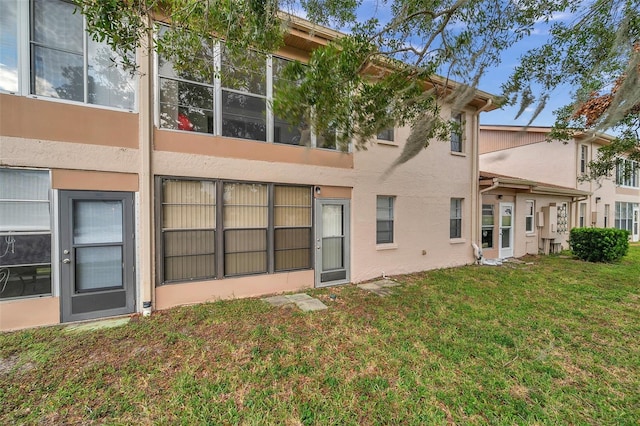 rear view of property featuring a lawn