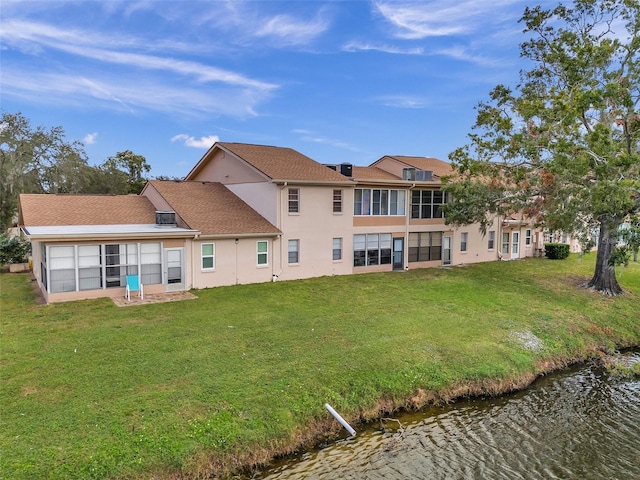 rear view of property featuring a water view and a yard