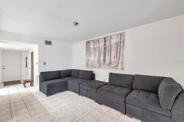 tiled living room featuring a textured ceiling