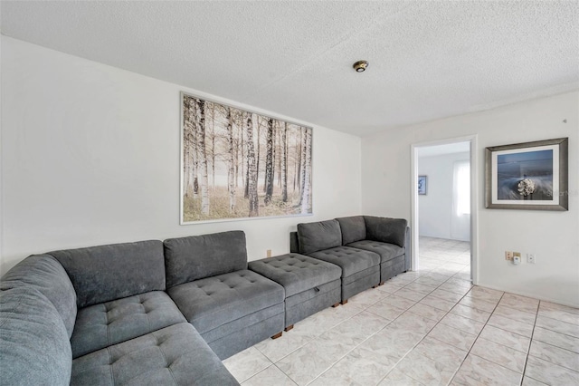 living room with a textured ceiling and light tile patterned floors