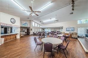 dining area with hardwood / wood-style flooring, rail lighting, ceiling fan, and lofted ceiling