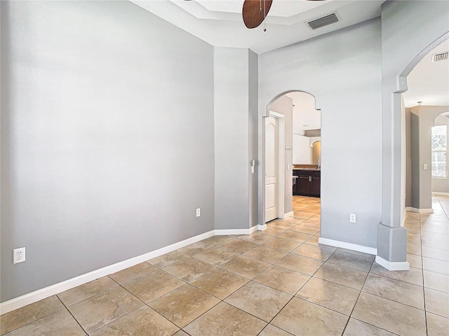 spare room with ceiling fan and light tile patterned floors