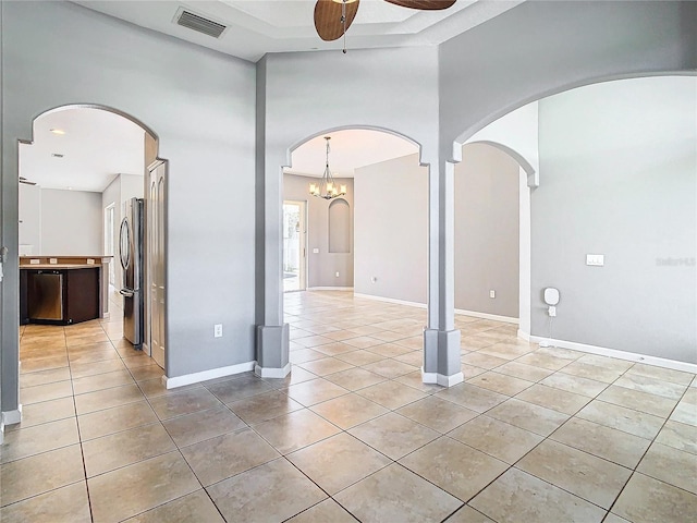 empty room with a high ceiling, light tile patterned flooring, and ceiling fan