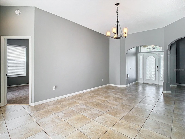 tiled foyer entrance featuring a notable chandelier