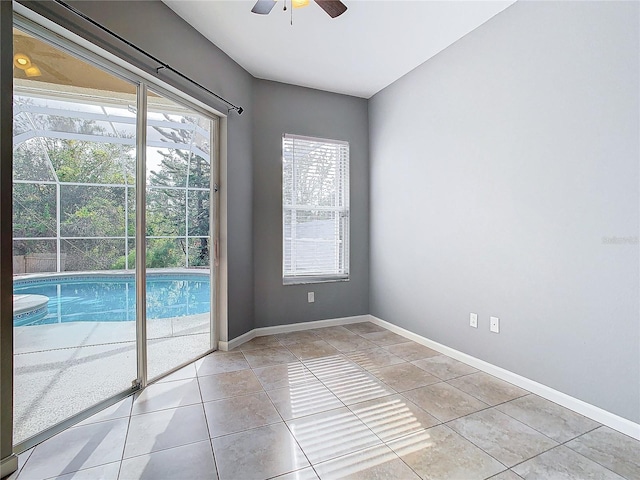 spare room with ceiling fan and light tile patterned flooring