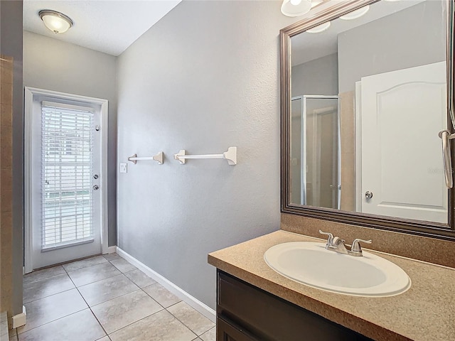 bathroom featuring vanity, a shower with shower door, and tile patterned flooring