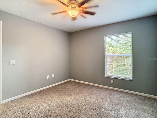 carpeted spare room featuring ceiling fan