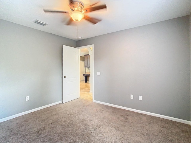 spare room featuring carpet floors and ceiling fan