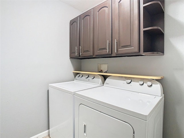 washroom featuring washing machine and dryer and cabinets