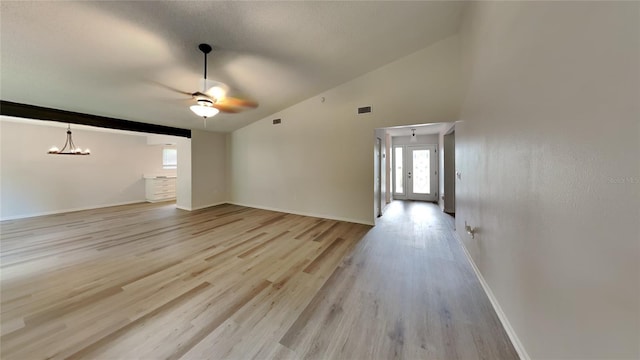 unfurnished living room featuring light hardwood / wood-style flooring, high vaulted ceiling, and ceiling fan with notable chandelier