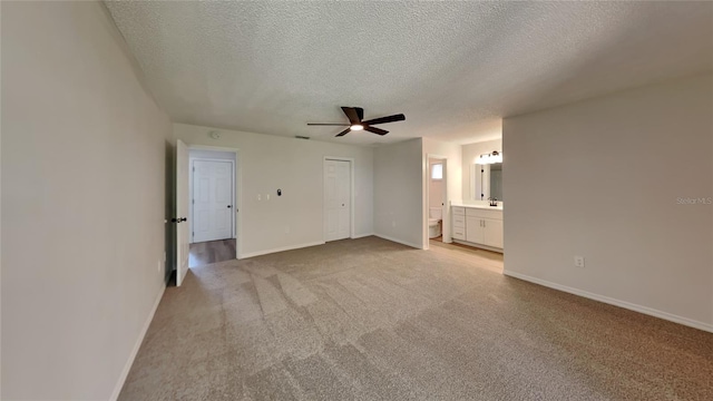 unfurnished living room featuring a textured ceiling, light colored carpet, and ceiling fan