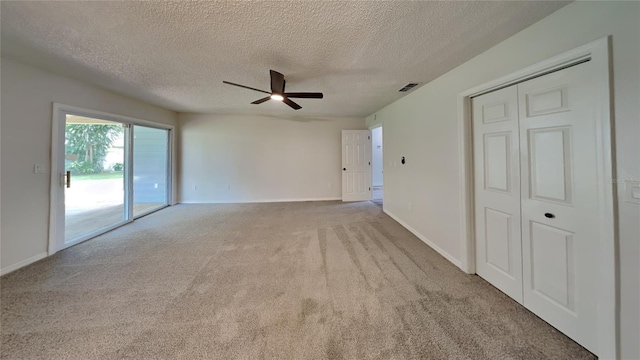 carpeted empty room with ceiling fan and a textured ceiling