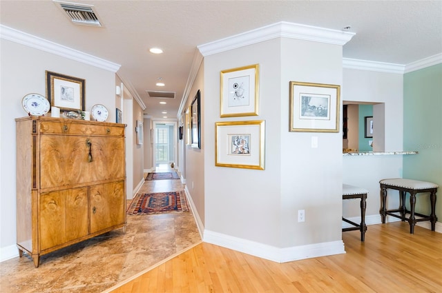 corridor with ornamental molding and hardwood / wood-style floors