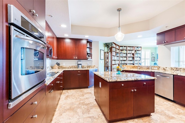 kitchen with kitchen peninsula, stainless steel appliances, a center island, pendant lighting, and light stone counters