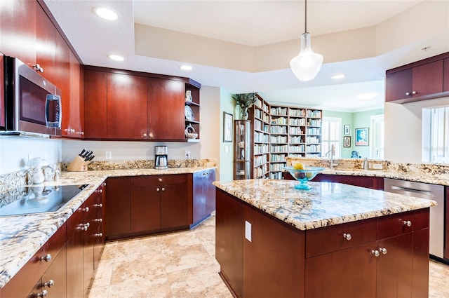 kitchen with pendant lighting, light stone counters, stainless steel appliances, and plenty of natural light