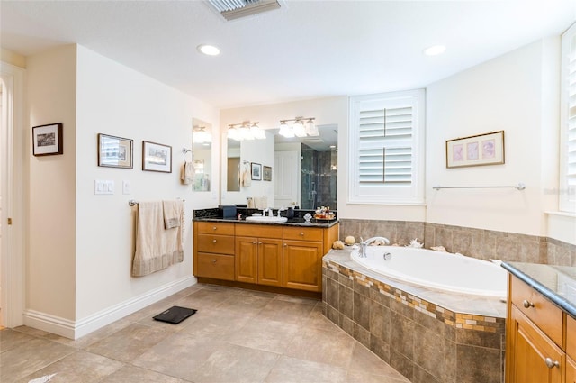 bathroom featuring vanity, independent shower and bath, a healthy amount of sunlight, and tile patterned flooring