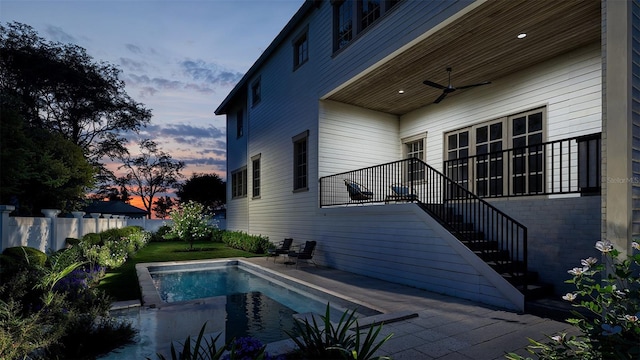 pool at dusk with a patio area