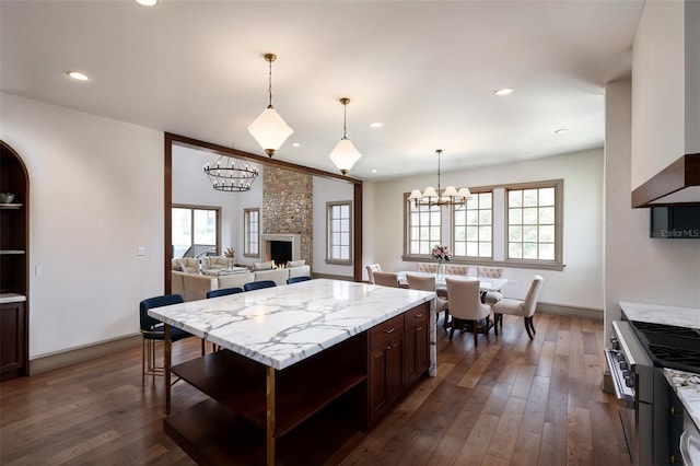 kitchen with dark hardwood / wood-style flooring, high end stainless steel range, a wealth of natural light, and dark brown cabinets