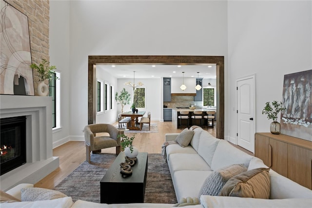 4633 W Lowell Ave, Tampa, FL 33629 - living area with a high ceiling, light wood-style floors, a fireplace, and baseboards