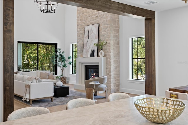 4633 W Lowell Ave, Tampa, FL 33629 - living area with wood finished floors, a chandelier, a glass covered fireplace, baseboards, and high vaulted ceiling