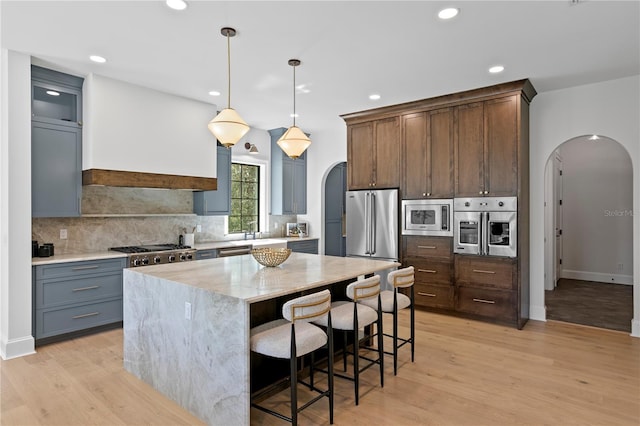 4633 W Lowell Ave, Tampa, FL 33629 - kitchen with arched walkways, stainless steel appliances, decorative backsplash, light stone counters, and recessed lighting