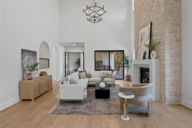 4633 W Lowell Ave, Tampa, FL 33629 - living area with baseboards, wood finished floors, a glass covered fireplace, a chandelier, and a high ceiling