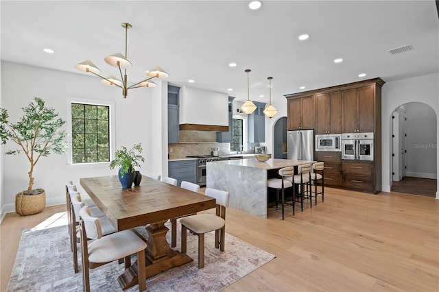 4633 W Lowell Ave, Tampa, FL 33629 - dining space featuring arched walkways, light wood-style flooring, recessed lighting, a chandelier, and baseboards
