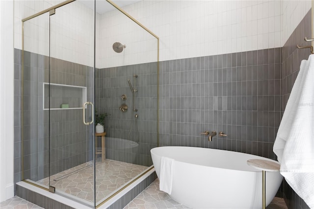 4633 W Lowell Ave, Tampa, FL 33629 - full bathroom with a soaking tub, a stall shower, tile walls, and tile patterned floors