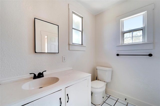 bathroom with toilet, vanity, and baseboards