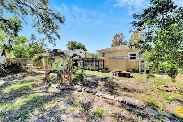 view of yard with a storage shed, a fenced backyard, and an outdoor structure