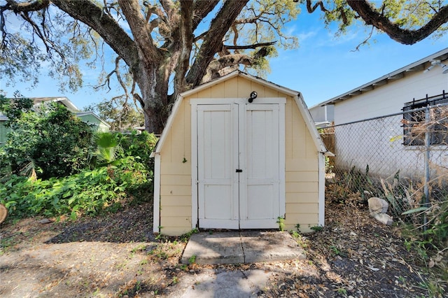 view of shed featuring fence