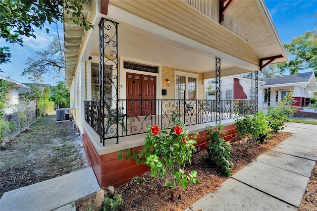 view of front of property with covered porch, fence, and central air condition unit