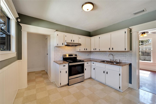 kitchen featuring light floors, stainless steel electric range, white cabinetry, and a sink