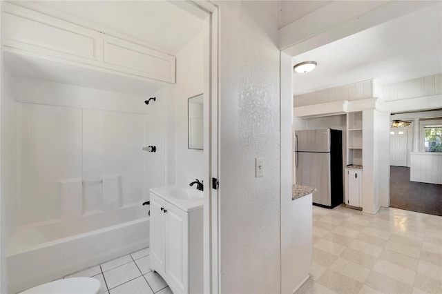 bathroom featuring shower / bath combination, a textured wall, toilet, vanity, and tile patterned floors