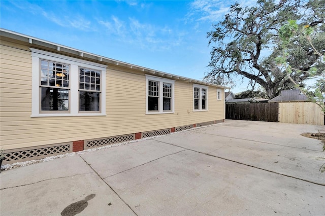 view of home's exterior featuring crawl space, a patio area, and fence