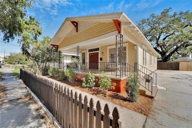 view of front facade with covered porch and a fenced front yard