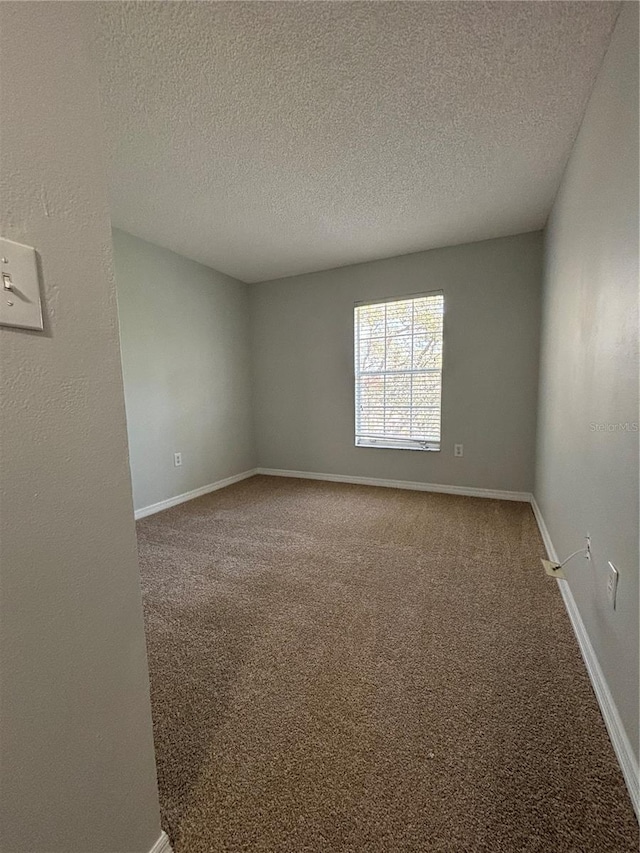 empty room featuring carpet and a textured ceiling