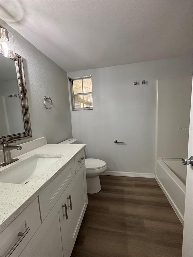 full bathroom featuring hardwood / wood-style floors, shower / tub combination, vanity, and toilet