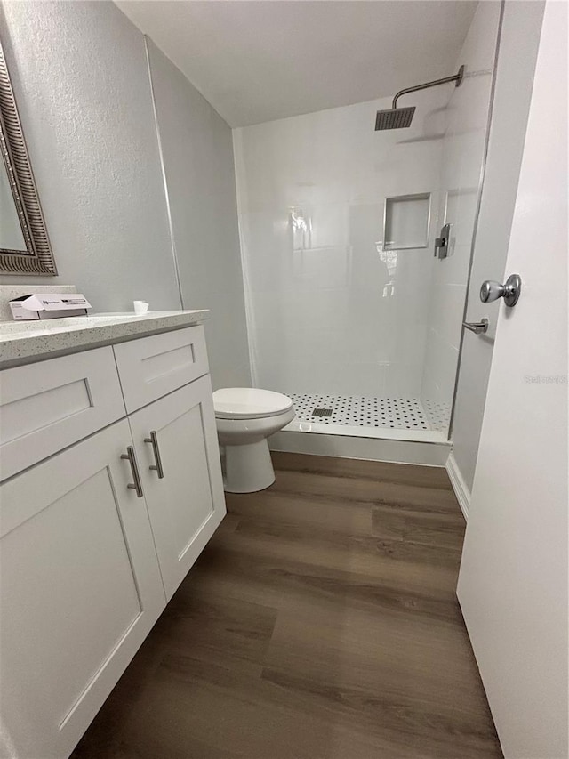 bathroom with walk in shower, wood-type flooring, toilet, and vanity