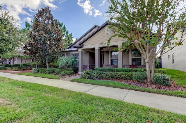 craftsman inspired home with a porch and a front lawn