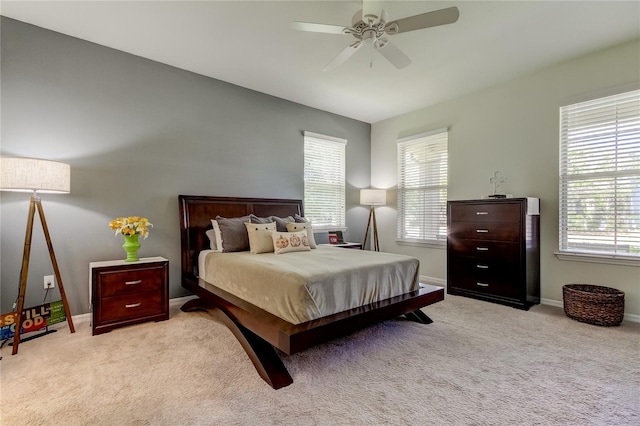 bedroom with multiple windows, light colored carpet, and ceiling fan