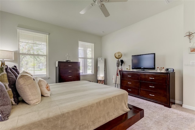 bedroom featuring multiple windows, light colored carpet, and ceiling fan